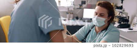 Skilled doctor performs ultrasound investigation while assistant holds animal in vet clinic 102829693