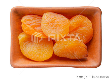 Dried apricots in clay bowl isolated on white flat lay view 102830650