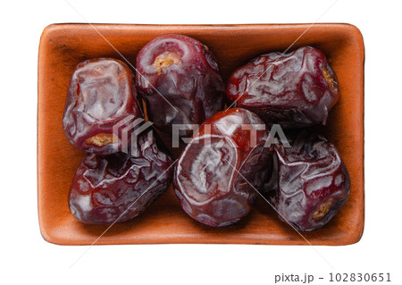 Dry dates in clay bowl isolated on white flat lay view Dry dates in clay bowl isolated on white flat lay view 102830651