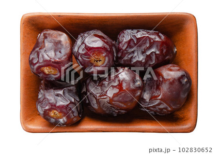 Dry dates in clay bowl isolated on white flat lay view Dry dates in clay bowl isolated on white flat lay view 102830652