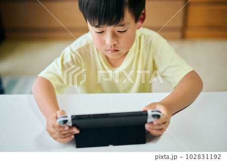 家庭用ゲーム機でゲームをする小学生の男の子 家庭用ゲーム機でゲームをする小学生の男の子 102831192
