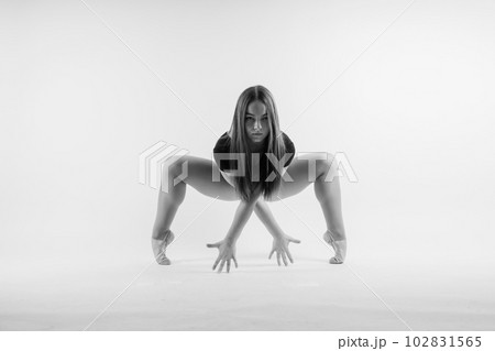 Flexible girl, rhythmic gymnastics artist jumping on white dark background. Grace in motion, action. Flexible girl, rhythmic gymnastics artist jumping on white dark background. Grace in motion, action. 102831565