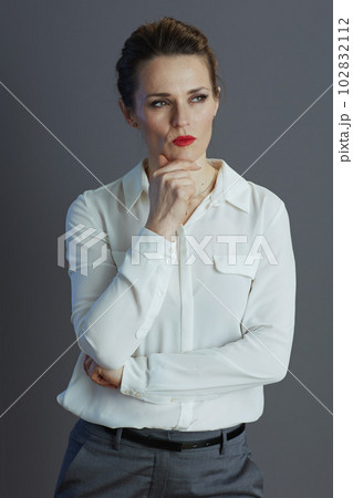 pensive modern woman employee against grey background 102832112
