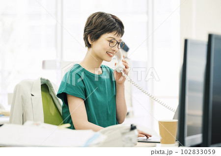 オフィスで電話応対をするキャリアウーマン 102833059