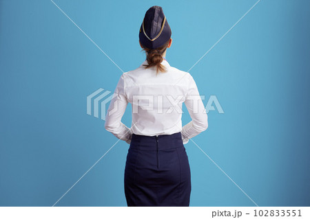 Seen from behind stylish air hostess woman on blue Seen from behind stylish air hostess woman on blue 102833551