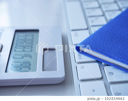 青い手帳とキーボード、電卓のビジネスイメージ 青い手帳とキーボード、電卓のビジネスイメージ 102834662