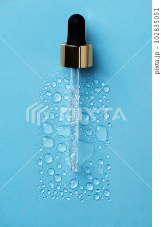 Drops of face serum top view. Liquid gel moisturizer. Creative idea of face serum with pipette on blue background. 102835051
