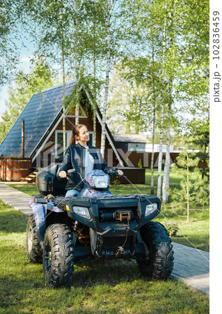 A woman who lives in country house uses ATV to navigate rough terrain A woman who lives in country house uses ATV to navigate rough terrain 102836459