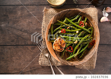 Roasted garlic green beans on wooden background. Top view, copy space Roasted garlic green beans on wooden background. Top view, copy space 102837036