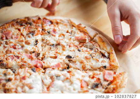 one people taking slices of pizza out of the box. fast delivery of food. packaging for fast food. top view one people taking slices of pizza out of the box. fast delivery of food. packaging for fast food. top view 102837827