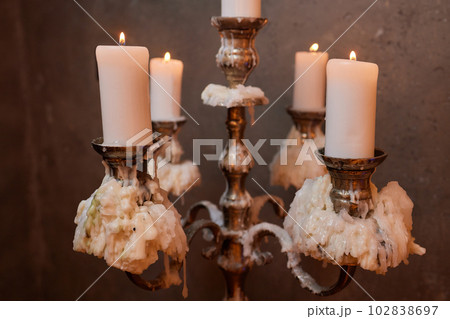 Light candle in the brass candlestick closeup on a dark background. Light candle in the brass candlestick closeup on a dark background. 102838697