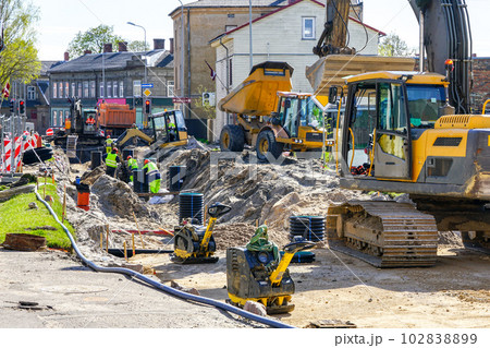 Street reconstruction site with several excavators, vibratory plate compactors and other machinery Street reconstruction site with several excavators, vibratory plate compactors and other machinery 102838899