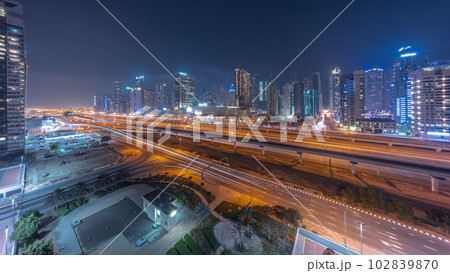 Dubai Marina skyscrapers and Sheikh Zayed road with metro railway aerial day to night timelapse, United Arab Emirates 102839870