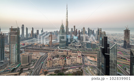 Aerial view of tallest towers in Dubai Downtown skyline and highway night to day timelapse. 102839901