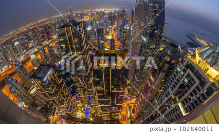 Skyline panorama of Dubai Marina showing canal surrounded by skyscrapers along shoreline day to night timelapse. DUBAI, UAE 102840011