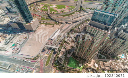 Aerial view of a road intersection between skyscrapers between skyscrapers all day timelapse. Aerial view of a road intersection between skyscrapers between skyscrapers all day timelapse. 102840071
