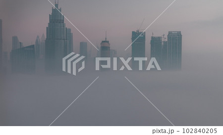 Aerial view morning fog covered Dubai International Financial Centre district night to day timelapse Aerial view morning fog covered Dubai International Financial Centre district night to day timelapse 102840205