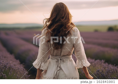 Young pretty woman standing back on the lavender field Young pretty woman standing back on the lavender field 102841001