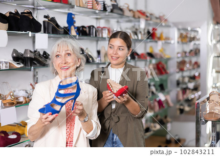 In store,cheerful female friends choose elegant spike heels or high heel sandals 102843211