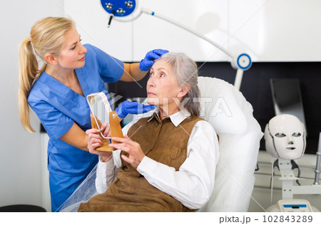 Cosmetologist and senior woman during doctor's appointment Cosmetologist and senior woman during doctor's appointment 102843289