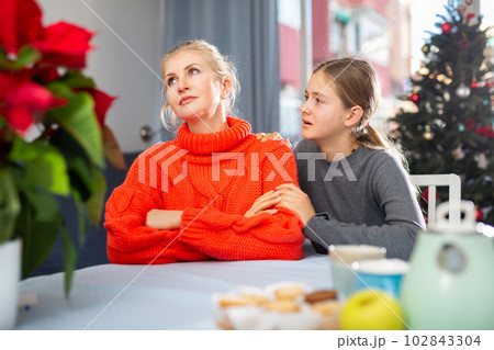 Daughter consoles mother 102843304