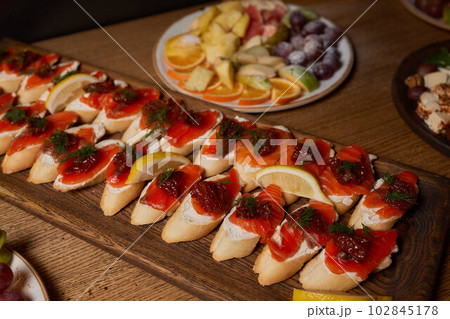 Banquet table with snacks, food on plates, festive table, corporate food 102845178