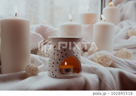 Aroma lamp with essential oil, aromatherapy at home, burning candle, dropping essential oil. Concept of home relaxation and anti stress. Natural Spa treatment Home fragnance at cozy home on the 102845518