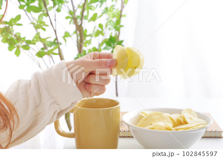 ポテトチップスを食べる女性 102845597
