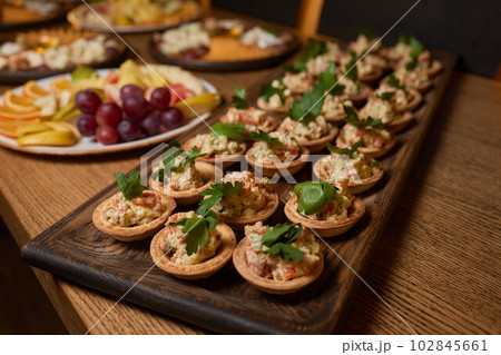 Banquet table with snacks, food on plates, festive table, corporate food Banquet table with snacks, food on plates, festive table, corporate food 102845661