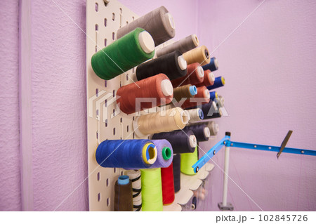 Set of various colorful threads placed on organizer in light workshop during daytime. Set of various colorful threads placed on organizer in light workshop during daytime. 102845726