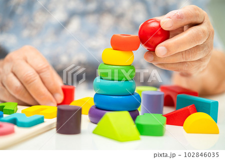 Alzheimer disease AD, Asian elderly woman patient suffering from dementia learn practical motor skills rehabilitation. 102846035