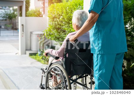 Caregiver help and care Asian senior or elderly old lady woman patient sitting on wheelchair to ramp in nursing hospital, healthy strong medical concept. 102846040