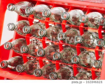 赤いプラスチックラックに入れられたジュースの空き瓶 赤いプラスチックラックに入れられたジュースの空き瓶 102846828