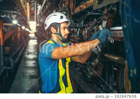 worker working in  industrial factory uses a cross screwdriver to inspect the machine. 102847638
