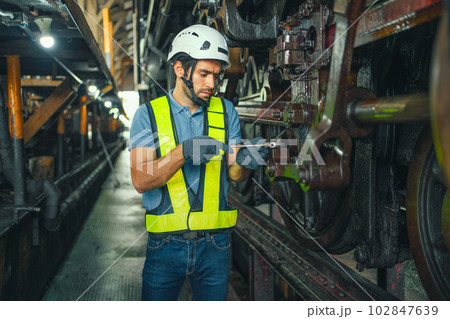 worker working in an industrial factory uses a cross screwdriver to inspect the machine. 102847639