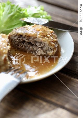 半分にカットしたガーリックペッパーソースのハンバーグ 102848448