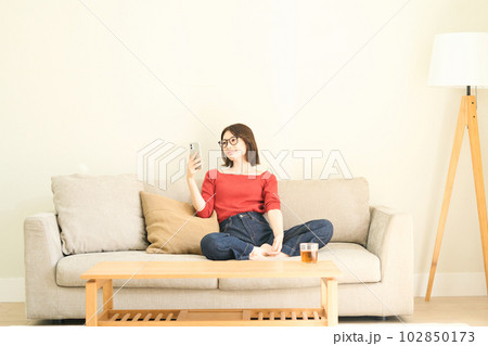 私服の若い女性 リビング スマホ 私服の若い女性 リビング スマホ 102850173