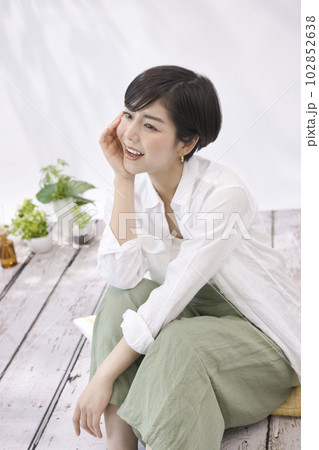 リビングで座ってくつろぐ若い女性 リビングで座ってくつろぐ若い女性 102852638