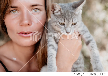 Woman summer travel cat. A woman on vacation with her pet cat enjoying a photo session on the beach. Travel and holiday concept. Woman summer travel cat. A woman on vacation with her pet cat enjoying a photo session on the beach. Travel and holiday concept. 102853112