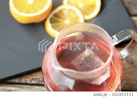ティーバッグで淹れるハーブティーのガラスポットとオレンジ 102853131