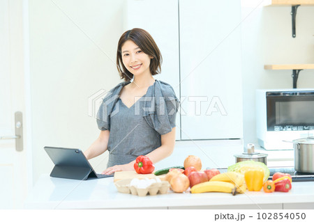 料理のレシピを見る若い女性 102854050
