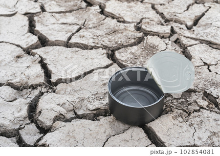 Empty tin can on the dried out earth with no water Empty tin can on the dried out earth with no water 102854081