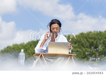 アウトドアでPC作業をする男性　テレワーク　ワーケーション　イメージ 102854563