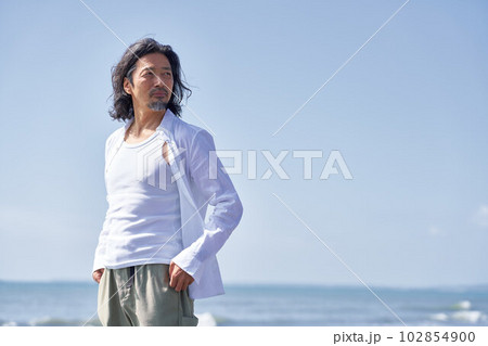 海辺にて遠くを見る年配の男性　ポートレート 102854900