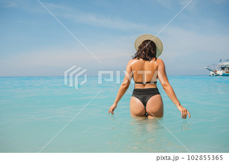 sexy woman in the blue sea water view from behind sexy woman in the blue sea water view from behind 102855365