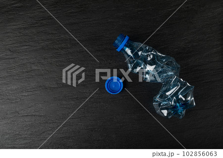 Blue Empty Plastic Bottle on Black Background, Crumpled Plastic Bottle, Global Pollution Concept Blue Empty Plastic Bottle on Black Background, Crumpled Plastic Bottle, Global Pollution Concept 102856063