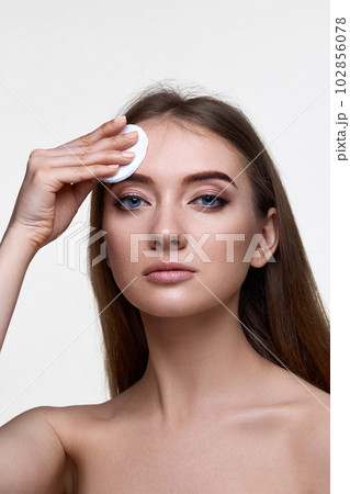 woman holding white cotton pad for removing makeup 102856078