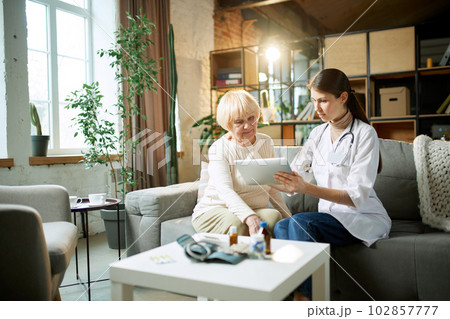 Senior woman visiting doctor, at appointment, consultation checking health in clinic, hospital on daytime. 102857777