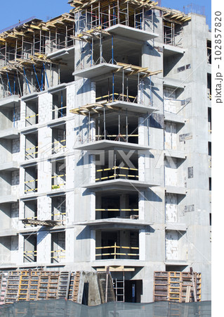 Construction site. Reinforced concrete frames of multi-storey buildings and construction cranes. Against the background of the blue sky. 102857820