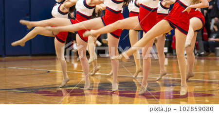 High school kickline performing on in a gym 102859080